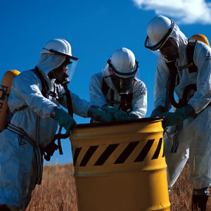 three hazardous waste workers with barrel